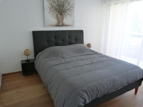 un grand lit dans une chambre avec une grande fenêtre dans l'établissement Parc Baie des Anges, à Villeneuve-Loubet