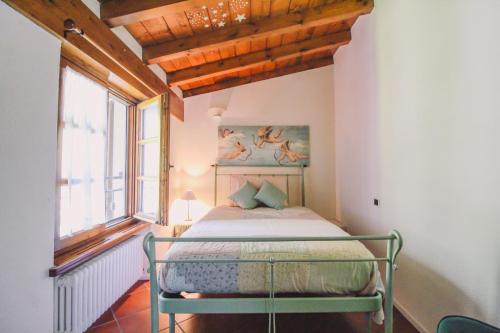 1 dormitorio con 1 cama en una habitación con ventana en Mansarda Amore, en Cadenabbia