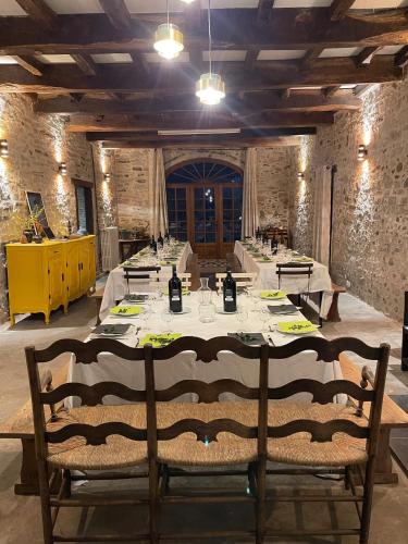 une longue table avec des chaises dans une pièce aux murs de briques dans l'établissement Ohikoa, à Saint-Étienne-dʼOrthe