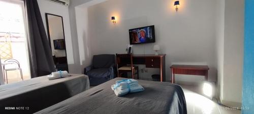 a living room with two beds and a television at Hotel Alnacir in Faro