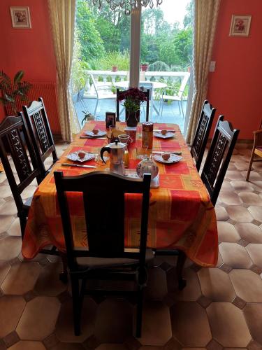 une table à manger avec des chaises et un tissu de table dans l'établissement Welcome Chez MARIE, à Aire-sur-la-Lys