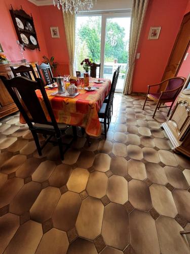 d'une salle à manger avec une table, des chaises et des murs rouges. dans l'établissement Welcome Chez MARIE, à Aire-sur-la-Lys