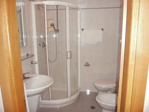 W łazience znajduje się prysznic, umywalka i toaleta. w obiekcie Hotel Manzoni w mieście Ponte San Giovanni