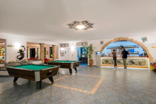 a living room with two pool tables and an arcade at Ekaterini Hotel in Kiotari