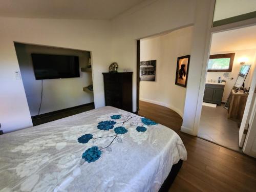 a bedroom with a bed with blue flowers on it at little cozy house in a village in Mountain Dale