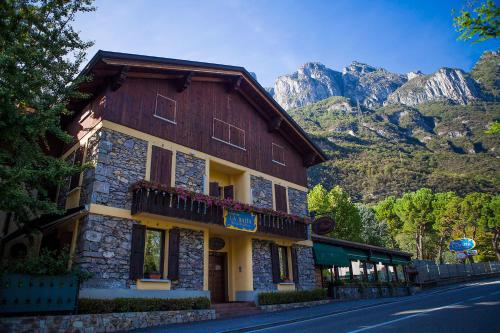 a building on the side of a street with a mountain at La Baita in Boario Terme
