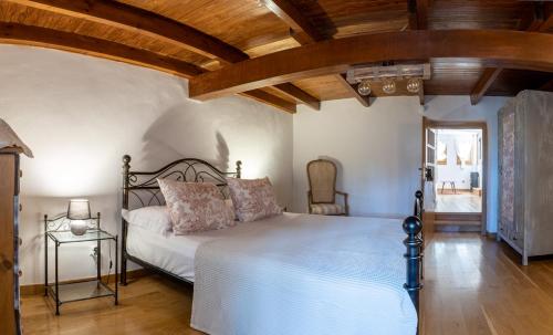 een slaapkamer met een bed en een houten plafond bij Gaia The Stone Cottage in Kórinthos