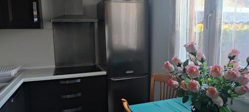 une cuisine avec une table et un vase de roses roses roses dans l'établissement Maison T2 Climatisée avec petit jardin dans impasse calme, à Baillargues