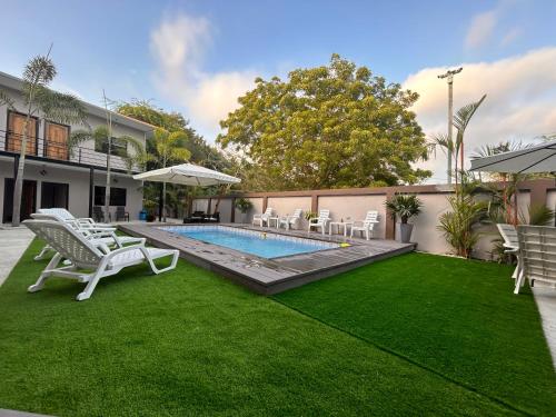 a backyard with a swimming pool and lawnitures at OCEAN DRIVE LODGE in Montañita