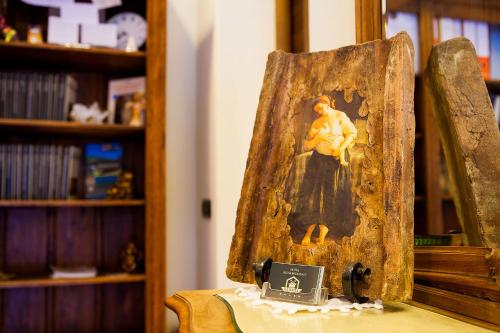 a painting of a woman sitting on a chair at La Baita in Boario Terme