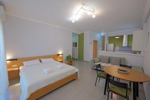 ein Schlafzimmer mit Bett und Tisch und eine Küche in der Unterkunft Get comfy in Sarandë