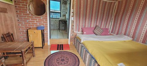 a bedroom with a bed in a room with a brick wall at Du Gia View Homestay in Làng Cac