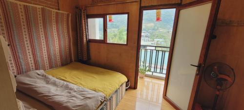 a small bedroom with a bed and a balcony at Du Gia View Homestay in Làng Cac