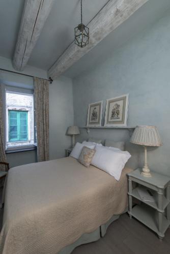 a bedroom with a bed and two lamps and a window at Relais Del Maro in Borgomaro