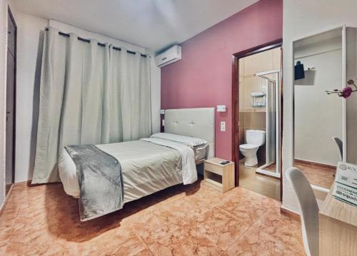 Dormitorio pequeño con cama y aseo en Hostal Rocamar en Almuñécar