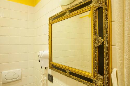 a gold framed mirror on the wall of a bathroom at La Baita in Boario Terme