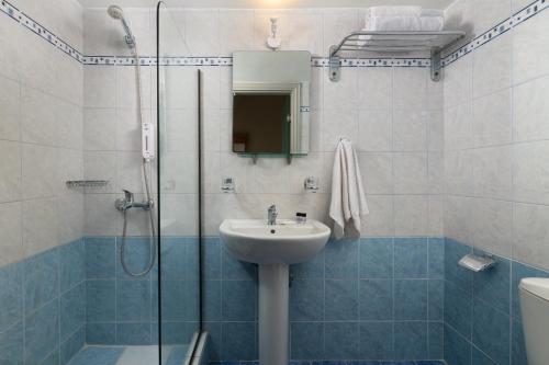 y baño con lavabo y ducha acristalada. en City Plus Rhodes Hotel, en Rodas