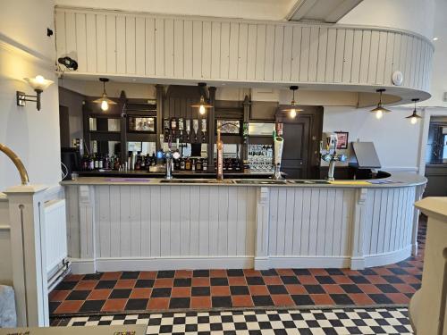 a bar in a pub with a checkered floor at Midlands Hotel in Mansfield