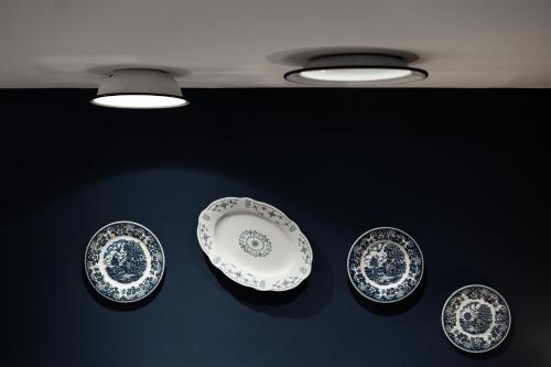 three blue and white plates on a table with lights at august träumt - das tiroler apartment im blauen in Matrei am Brenner