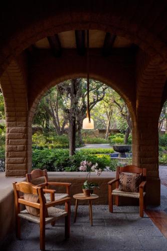 a patio with two chairs and a table and a window at Mision del Sol Resort & Spa Adults Only in Cuernavaca