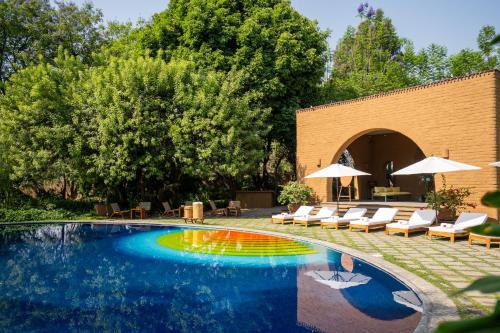 a pool with chairs and umbrellas in a yard at Mision del Sol Resort & Spa Adults Only in Cuernavaca