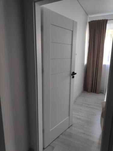 a white door in a room with a hallway at Aušros Alėjos Apartamentai in Šiauliai