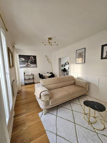 un salon avec un canapé et une table dans l'établissement Appartement luxe - Colombes, à Colombes