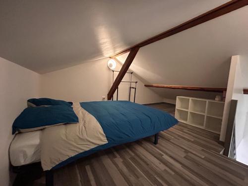 a bedroom with a large bed with blue pillows at Petite Maison studio tout confort cosy Givors autoroute et gare in Givors