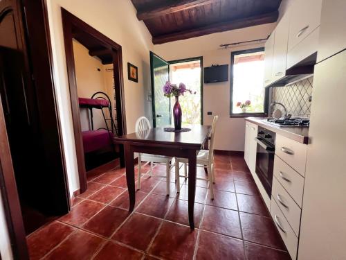 a kitchen with a table with a vase of flowers on it at Villabosco in Favara