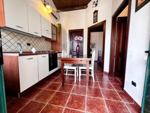 a kitchen with a table and chairs in a room at Villabosco in Favara