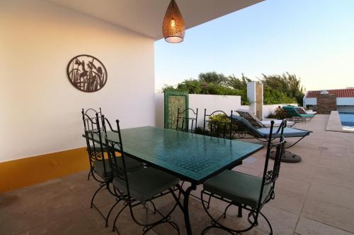 una sala da pranzo con tavolo e sedie in vetro di Fonte dos Pássaros a Vila Nova de Milfontes