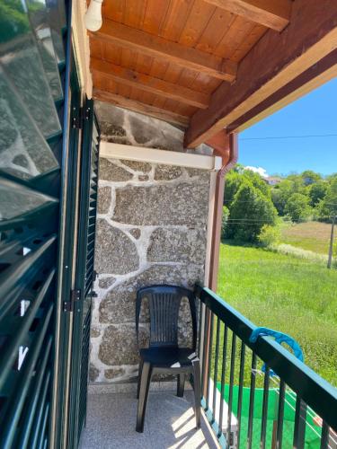 ein blauer Stuhl auf einer Veranda mit einer Steinmauer in der Unterkunft Casinha da Ti'Augusta in Lamego