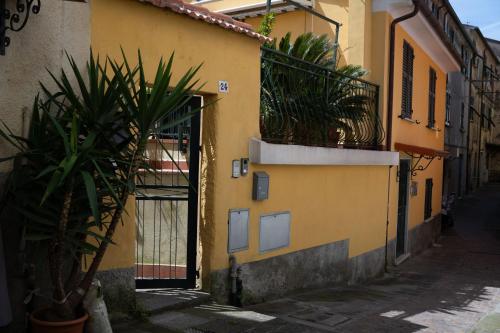 een steegje met een geel gebouw met een deur en planten bij House in Pitelli - close to the 5 Terre, Gulf of Poets, Tuscany in Pitelli