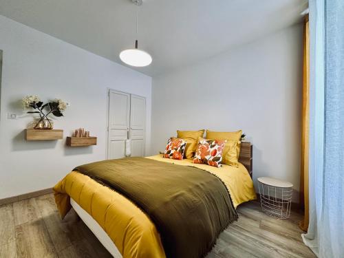 une chambre avec un lit avec des draps et des oreillers jaunes dans l'établissement Magnifique deux pièces au cœur d Ajaccio, à Ajaccio