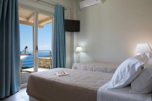 a bedroom with two beds with a view of the ocean at Ilios villa in Fternón