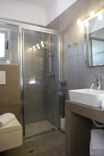 a bathroom with a shower and a sink at Ilios villa in Fternón