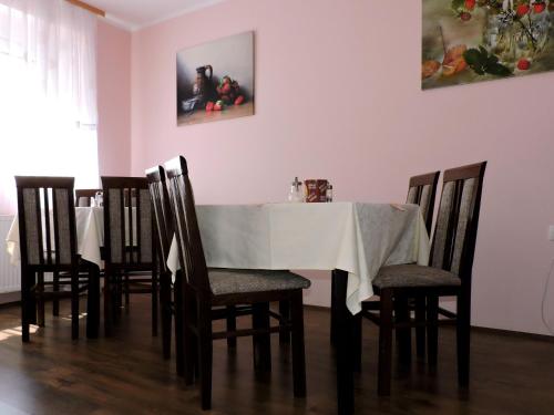 a dining room table with chairs and a white table cloth at B&B Zmajevo Gnezdo 021 in Sremska Kamenica