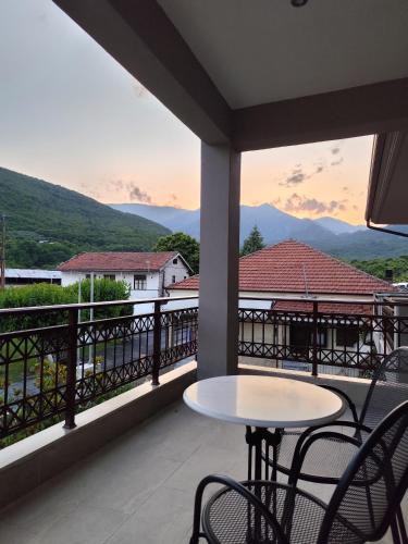 a balcony with a table and chairs and mountains at Ζέον Ύδωρ in Órma