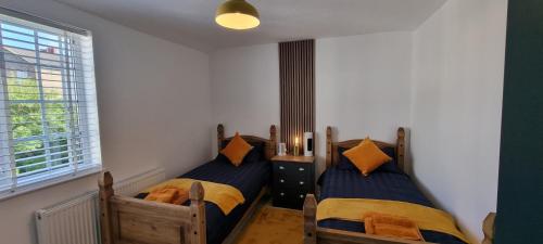 Dos camas individuales en una habitación con ventana. en The Hideaway ll private garden Quiet Central, en Southport