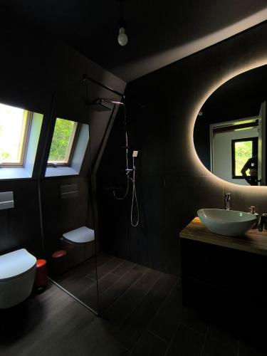 a black bathroom with a sink and a mirror at Cabana NucA-Frame Baia Mare in Satu Nou de Jos