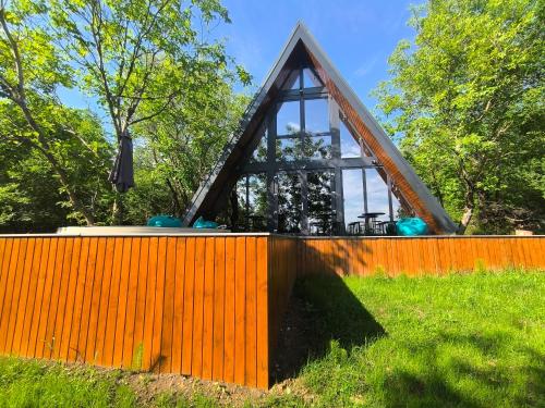 an orange fence with a building behind it at Cabana NucA-Frame Baia Mare in Satu Nou de Jos