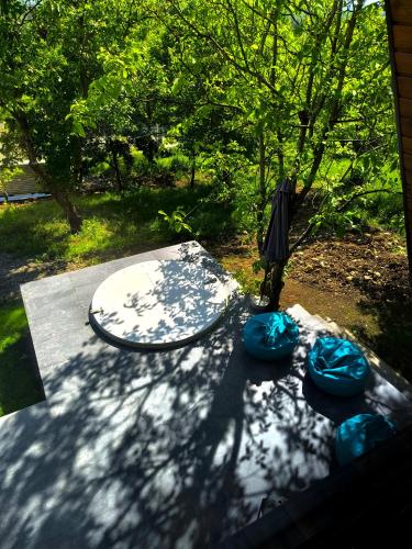 a surfboard and an umbrella sitting on a patio at Cabana NucA-Frame Baia Mare in Satu Nou de Jos