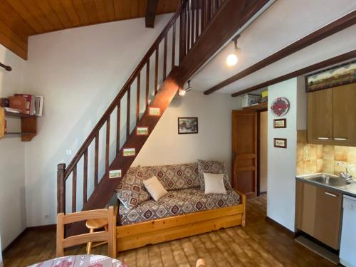- un salon avec un canapé sous un escalier dans l'établissement Studio avec mezzanine, balcon et parking à Châtel, proche des remontées mécaniques - FR-1-693-17, à Châtel