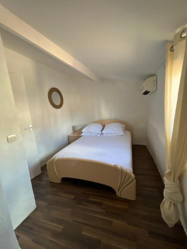 a bedroom with a bed with white sheets and a window at Cœur de CANNES centre ville in Cannes