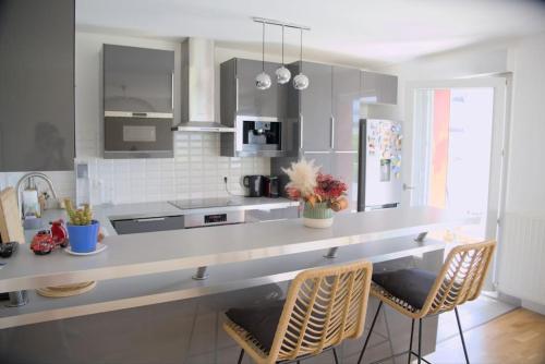 - une cuisine avec un comptoir et quelques chaises dans l'établissement Appartement Moderne et Spacieux, à Créteil