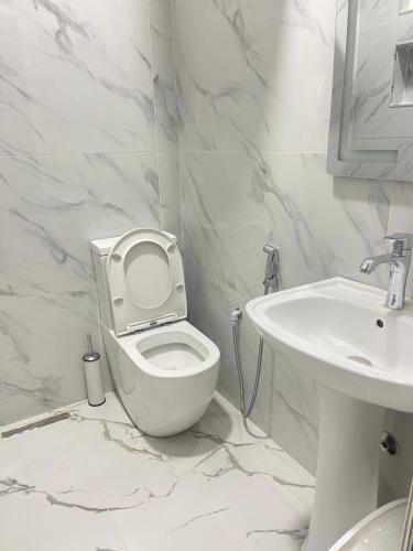 a white bathroom with a toilet and a sink at Rai Rooms in Durrës