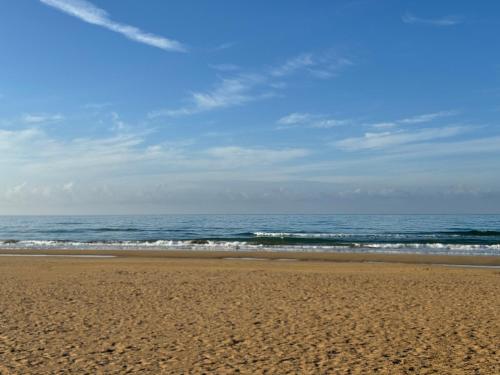 a sandy beach with the ocean in the background at Sun Holidays Home in Marina di Modica