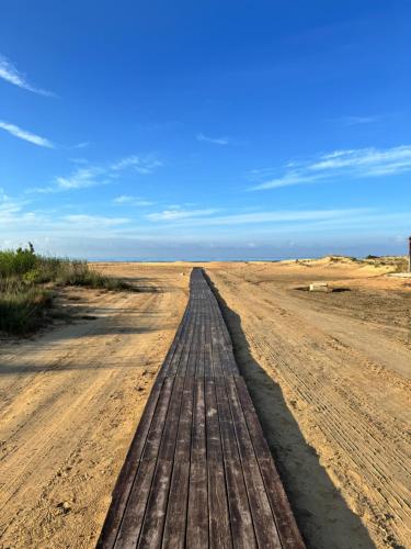 a dirt road in the desert with a wooden bridge at Sun Holidays Home in Marina di Modica