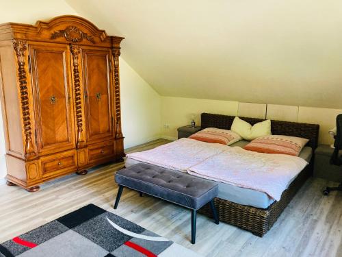 a bedroom with a bed and a large wooden cabinet at An der Glocke in Hennickendorf