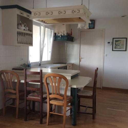 une cuisine avec une table, des chaises et un comptoir dans l'établissement Picherieux, à Saint-Denis-en-Val